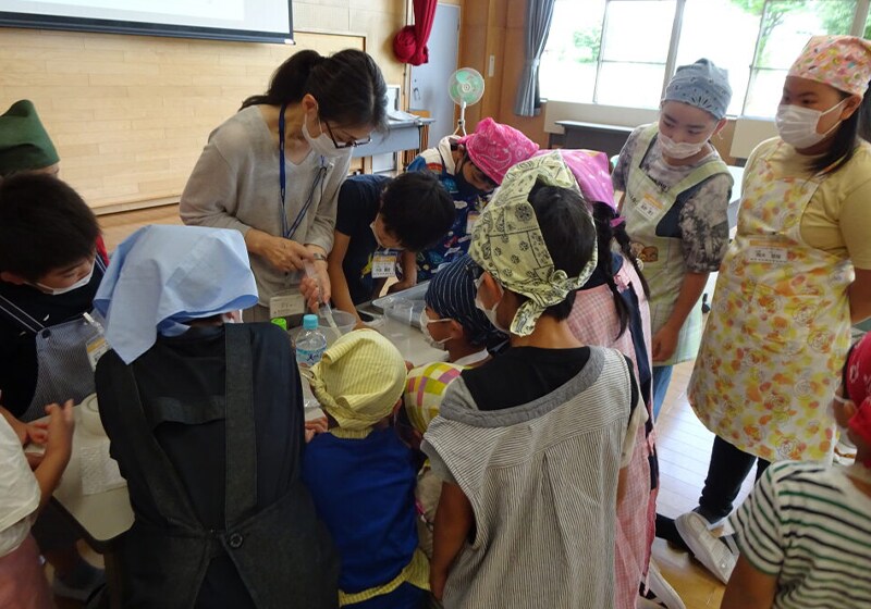 An educational event for elementary school students organized by Wanpaku Daigaku at a local community center. Toray employees helped students conduct filtration experiments using hollow fiber membranes in order to learn how to purify water. (Toray Industries, Inc. Nasu Plant)