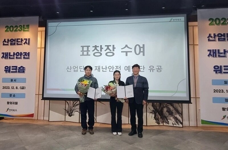 Leader of Power Team 1 (left) receiving the award with colleagues