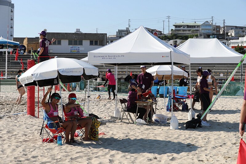 Players taking a break under a SUMMER SHIELD™ canopy during a match