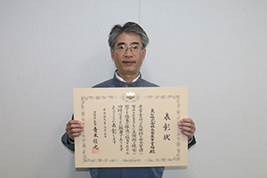 授与された表彰状を手に金井事業場長