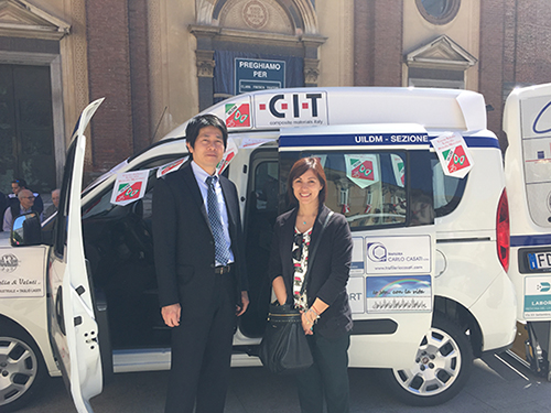 CIT社のロゴの入った介護サービス車の前で、久間田社長（左）とDimiccoliさん