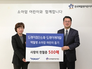韓国白血病子供財団に献血証５００枚を寄贈する金常務（左）