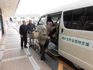 たくさんのお買い物をされた緑が丘町民の方と、お手伝いするOB支援隊員（写真左）