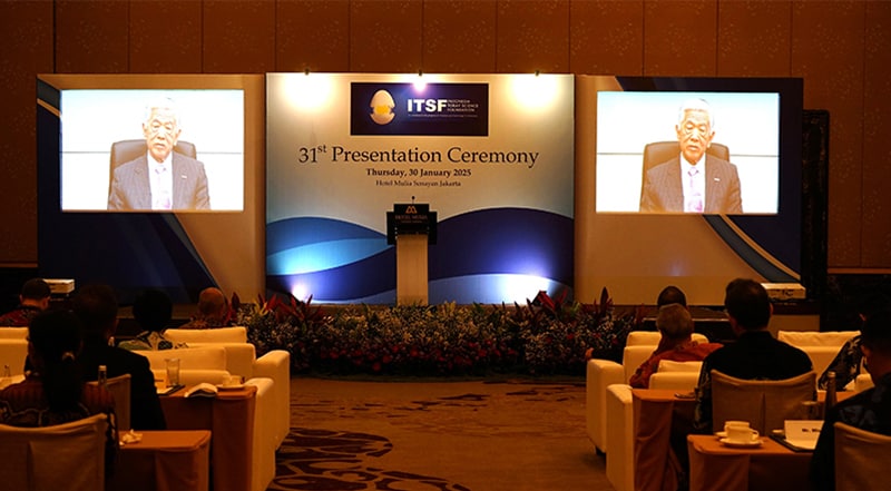 ビデオメッセージを通じて挨拶するITSF名誉会長の東レ（株）日覺会長