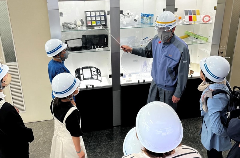 ショーケースに展示したABS樹脂製品を社員の家族に説明（東レ（株）千葉工場）