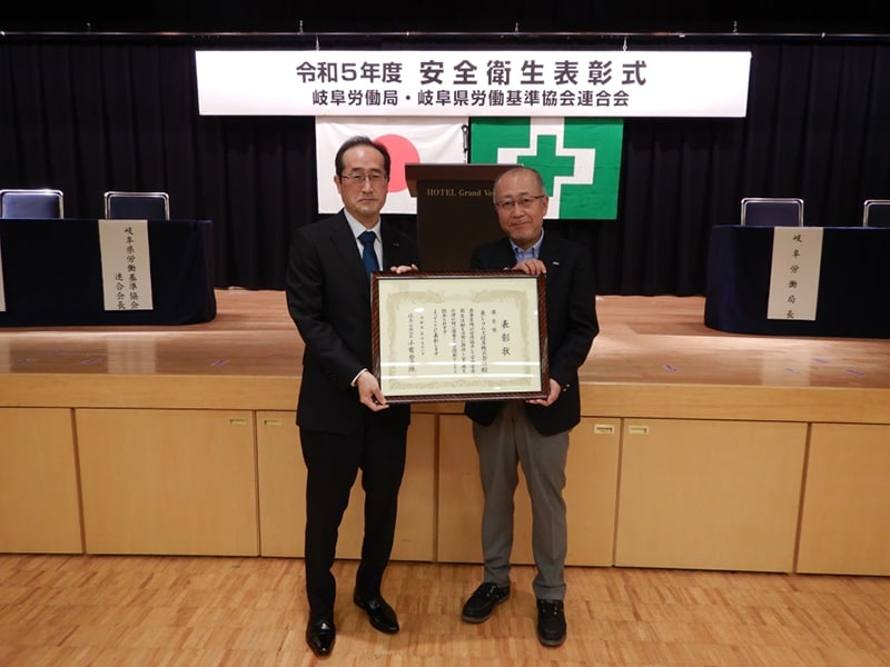 表彰状を手にする社長と作業部門長（東レコムズ岐阜（株））